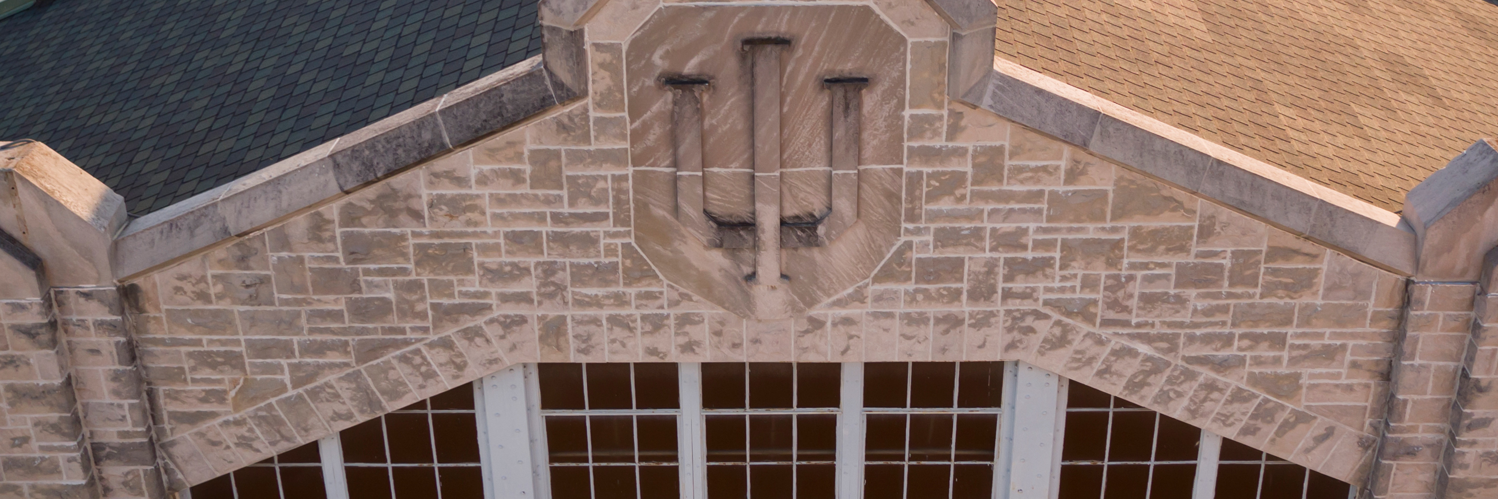 A limestone carving of the IU trident logo.