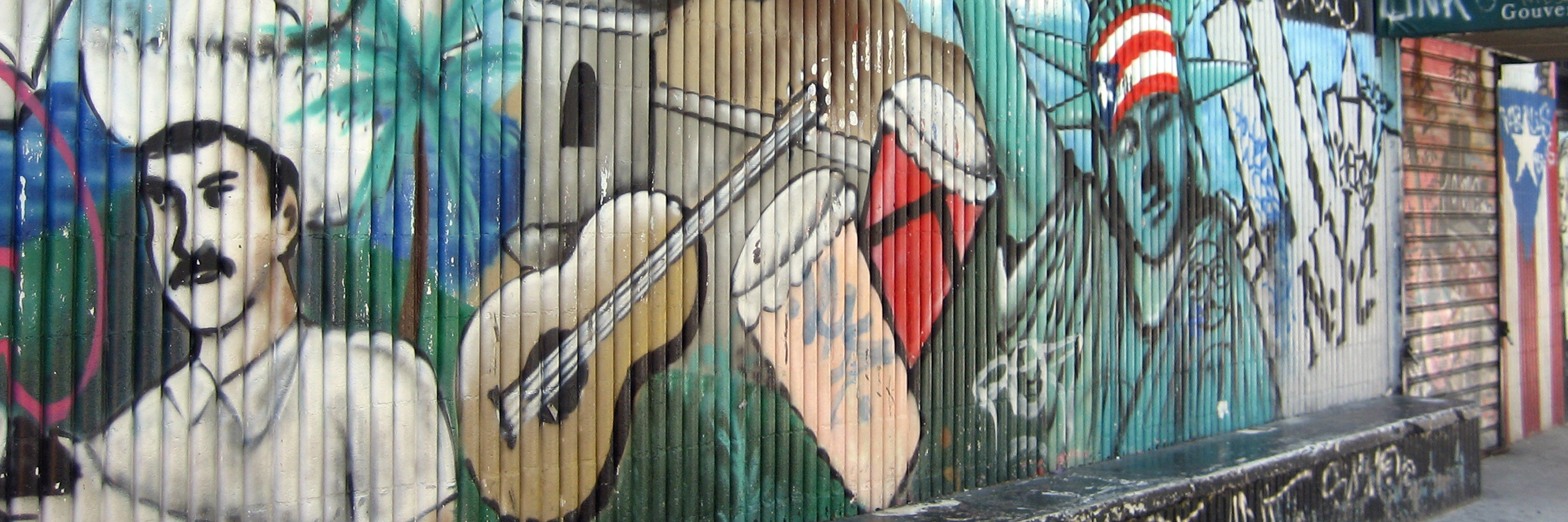 A graffiti mural on a fence in New York City with a flag of Puerto Rico.