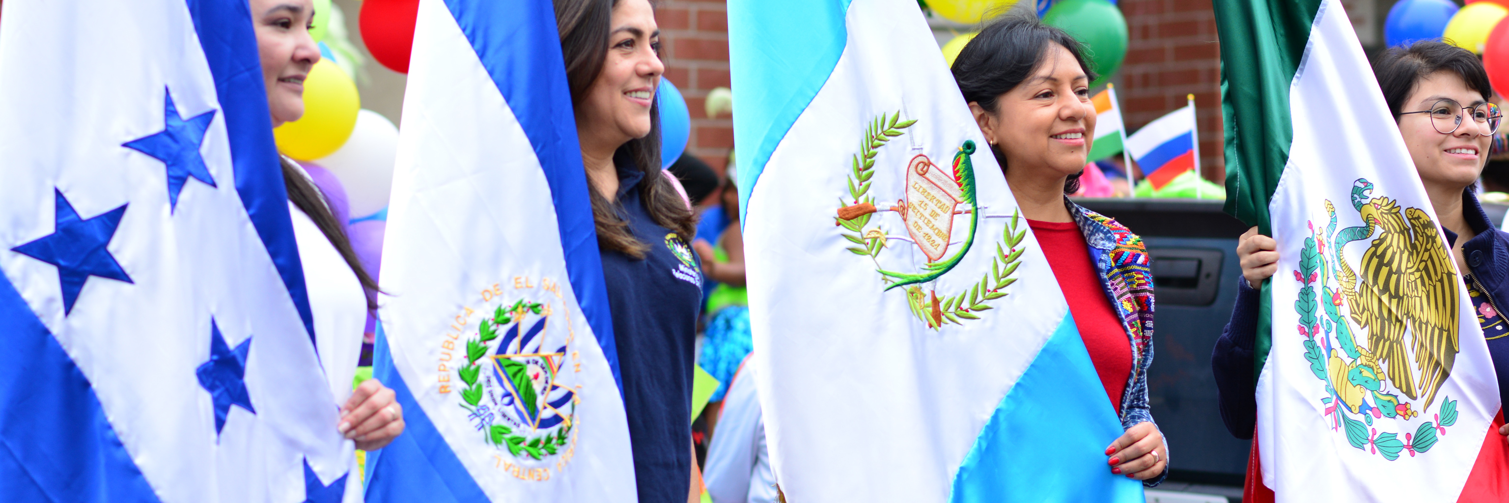 Women with flags preparing for a fiestas patrias parade.