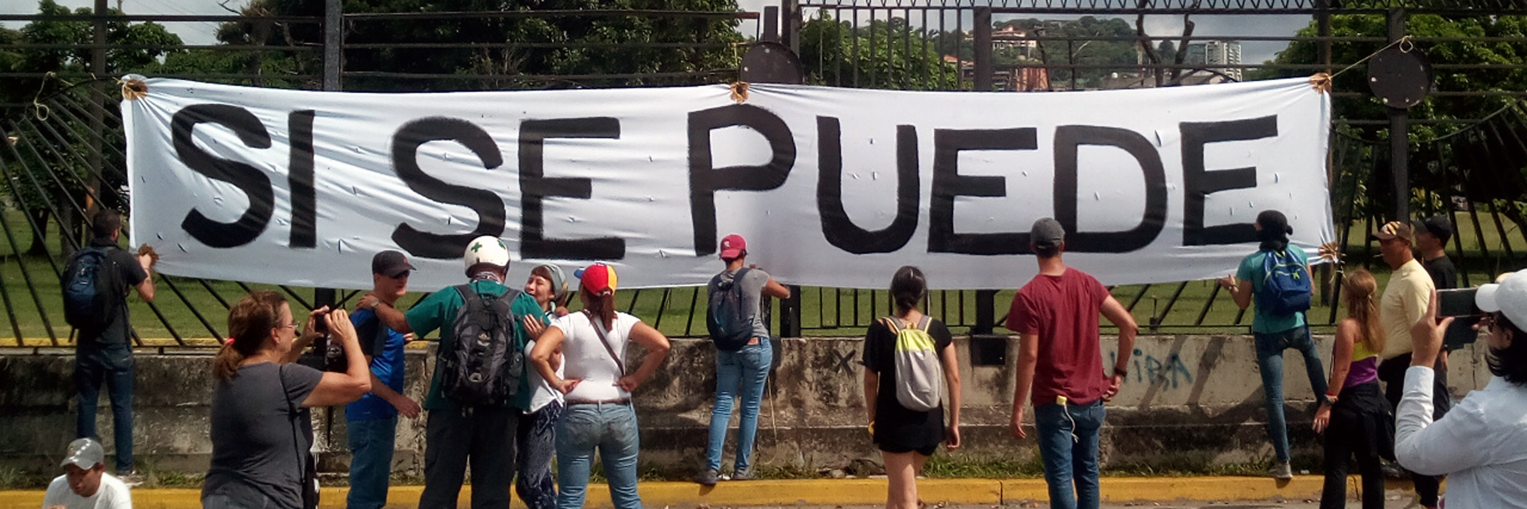 Protestors with a sign that reads Si Se Puede